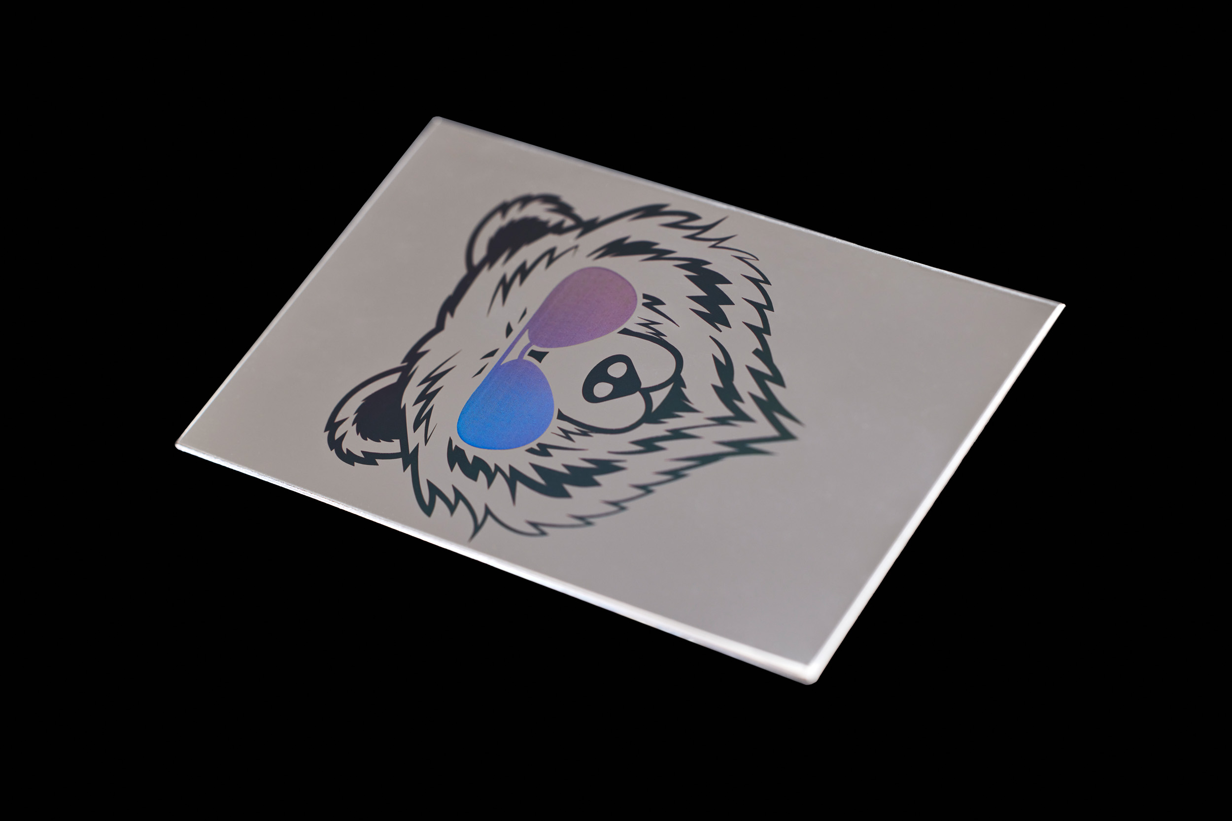 Ein cooler Bär mit einer holografischen Sonnenbrille, der mittels Laser auf einer Edelstahlplatte beschriftet wurde.