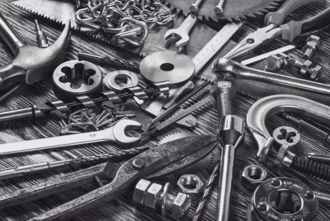 Viele verschiedene Werkzeuge auf einem Tisch, die den Maschinenbau und die Werkzeugindustrie symbolisieren.