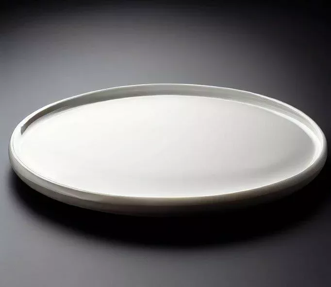 Runde flache Keramikplatte auf schwarzem Hintergrund als Material für die Laserbeschriftung.