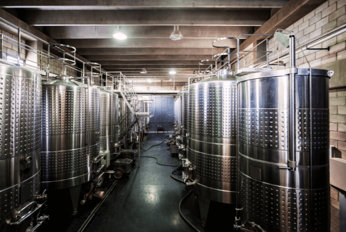 Fermentation tanks in a large hall. Representing the food industry.